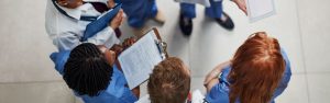 team-of-healthcare-providers-in-scrubs-talking-in-a-circle