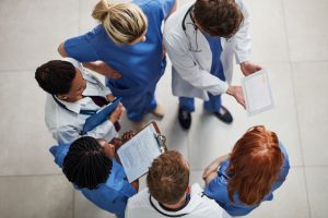team-of-healthcare-providers-in-scrubs-talking-in-a-circle