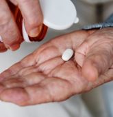 elderly-person-pouring-white-pill-out-of-prescription-bottle